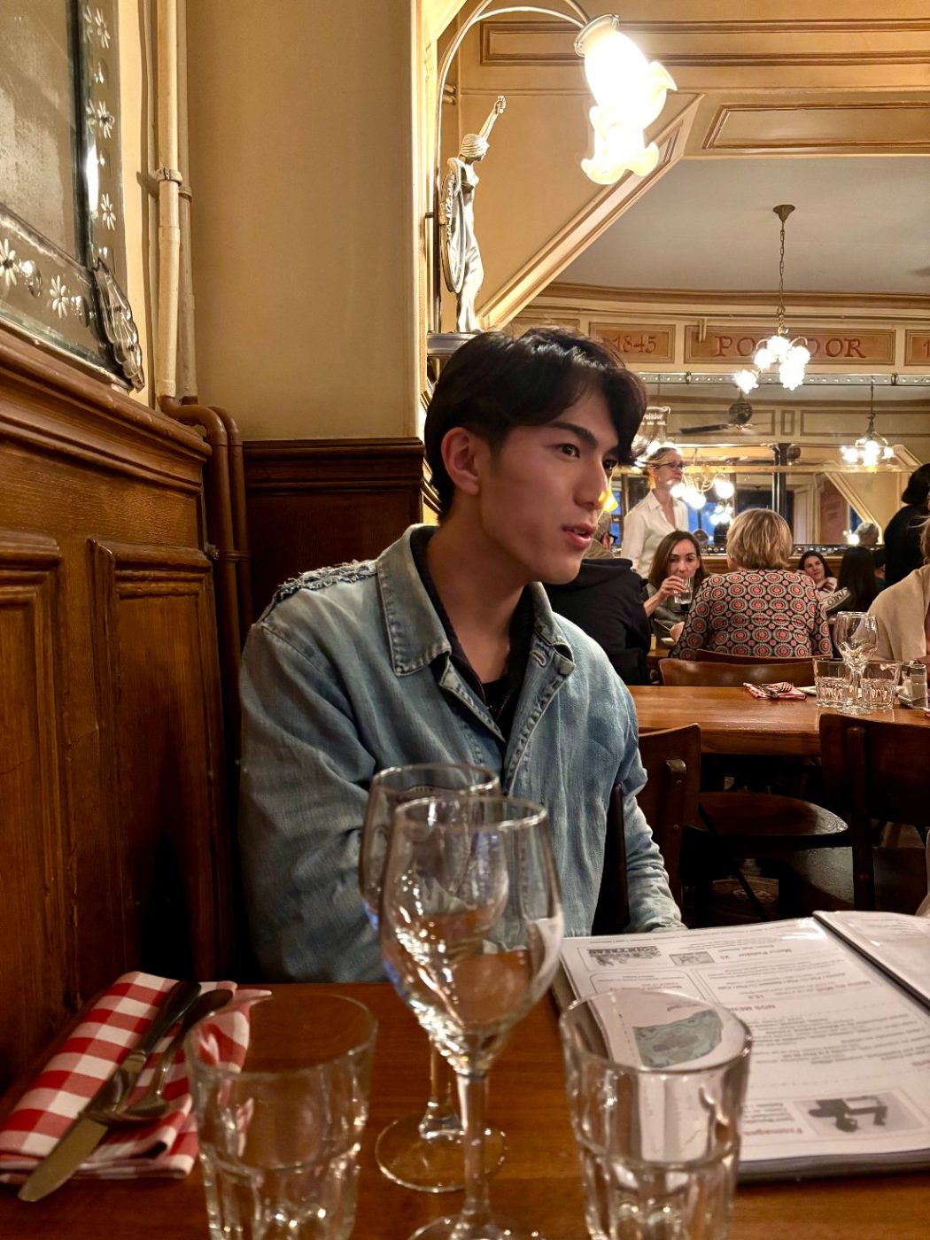 Shoki Sakuma in a denim jacket at a Paris bistro