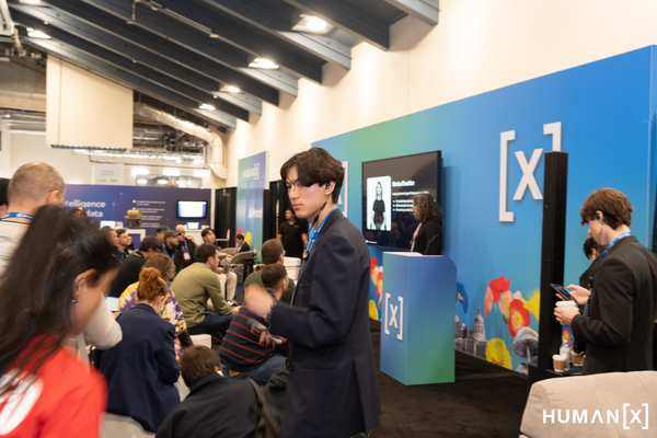 HumanX 2026 — Shoki Sakuma on the Agentic AI Pavilion floor with attendees gathered around a speaker presentation
